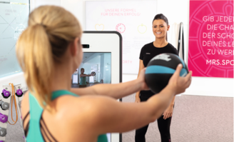 Mrs.Sporty Fitnesstrainerin und Mitglied beim Training am digitalen Smarttrainer